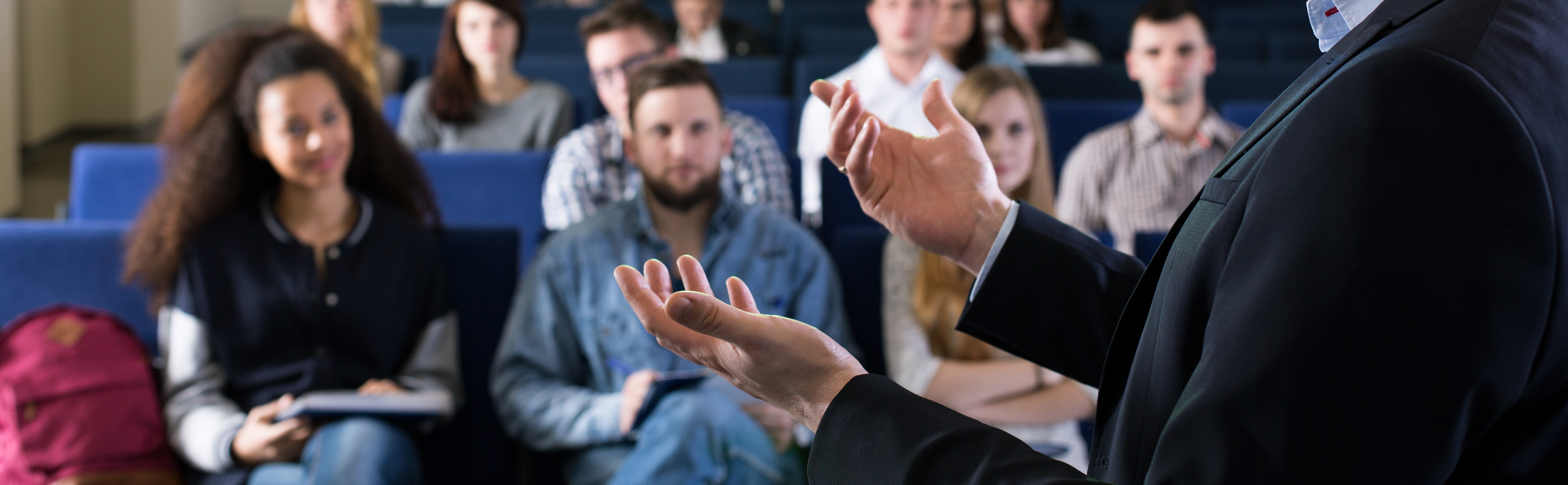 An instructor's hands gesture while lecturing to students.