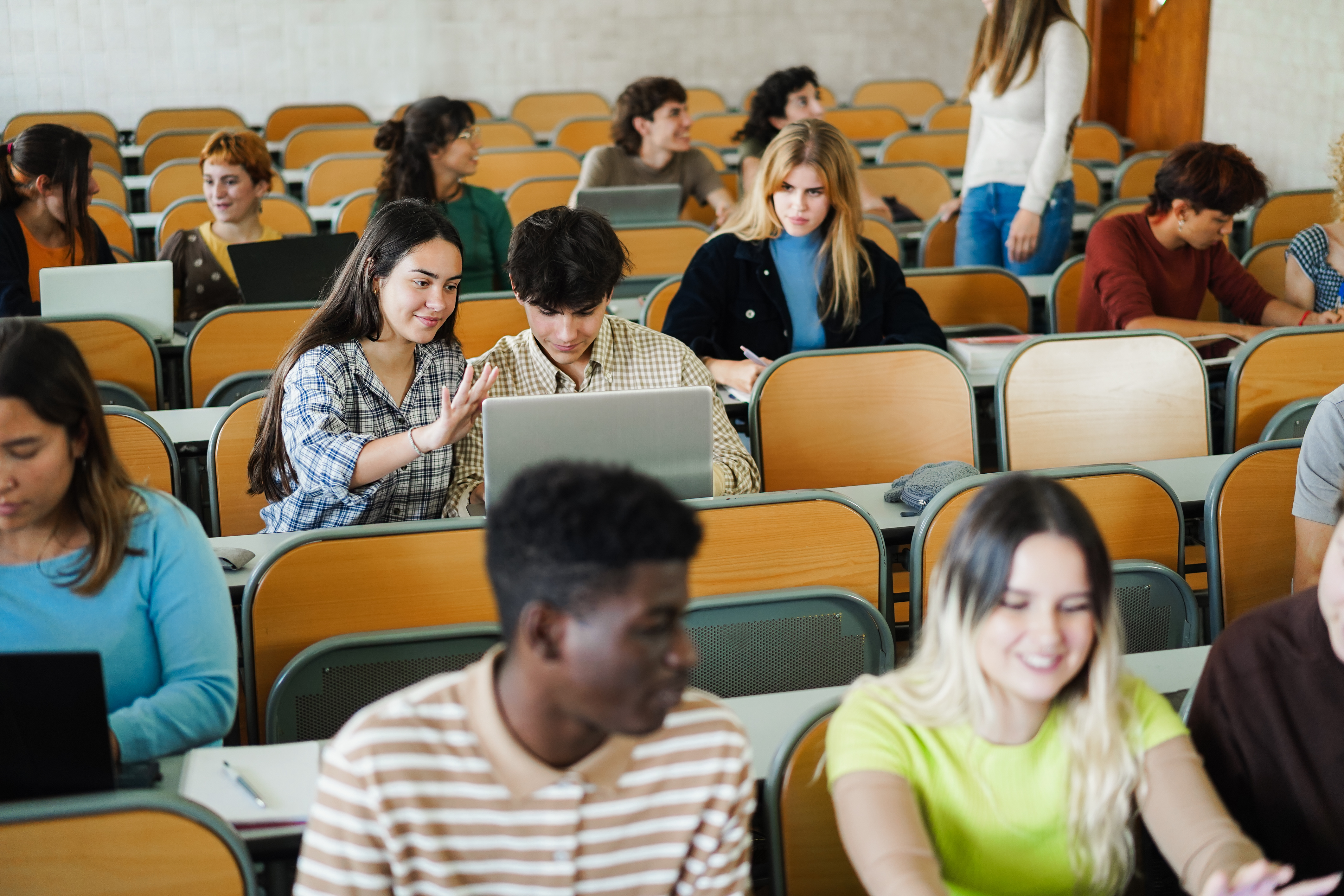 Students in a lecture hall work in pairs on an activity.