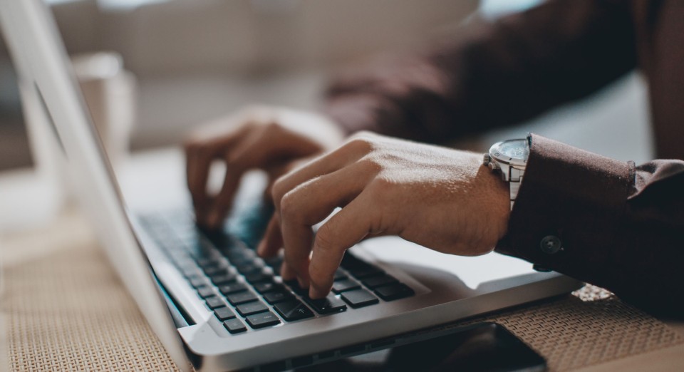 Male typing on a laptop