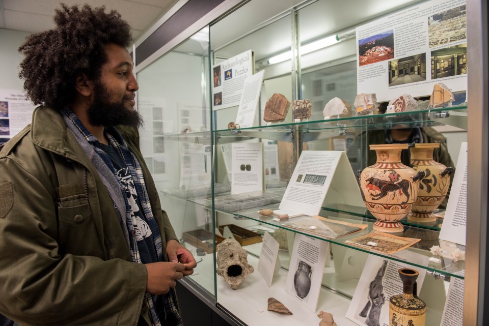 A student looks at artifacts in a museum.