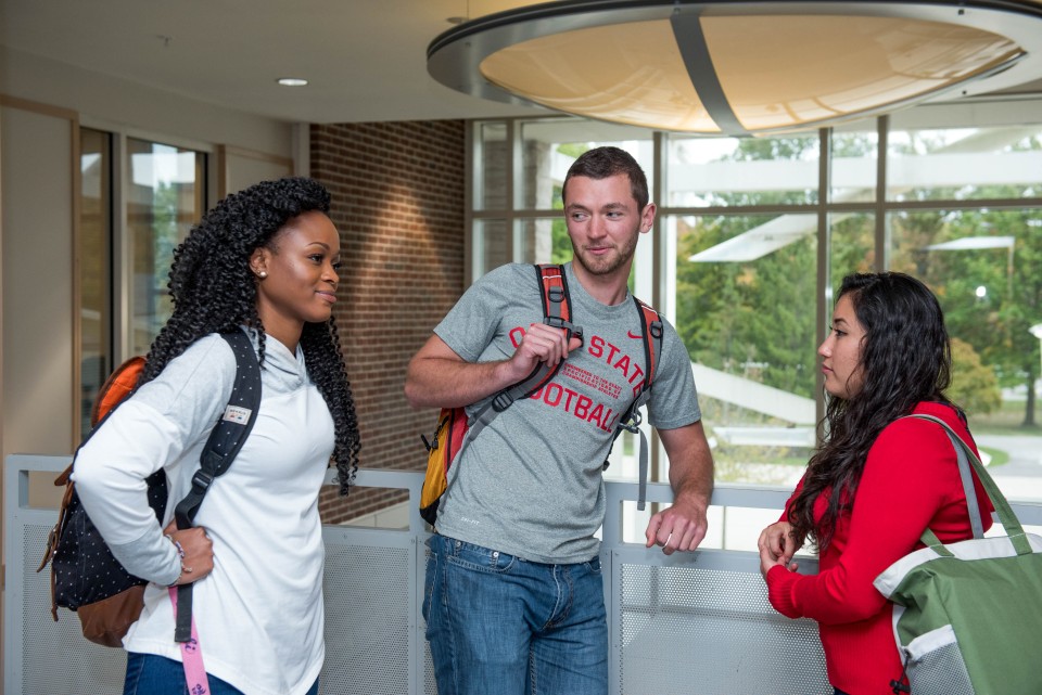 Three students engaged in conversation.
