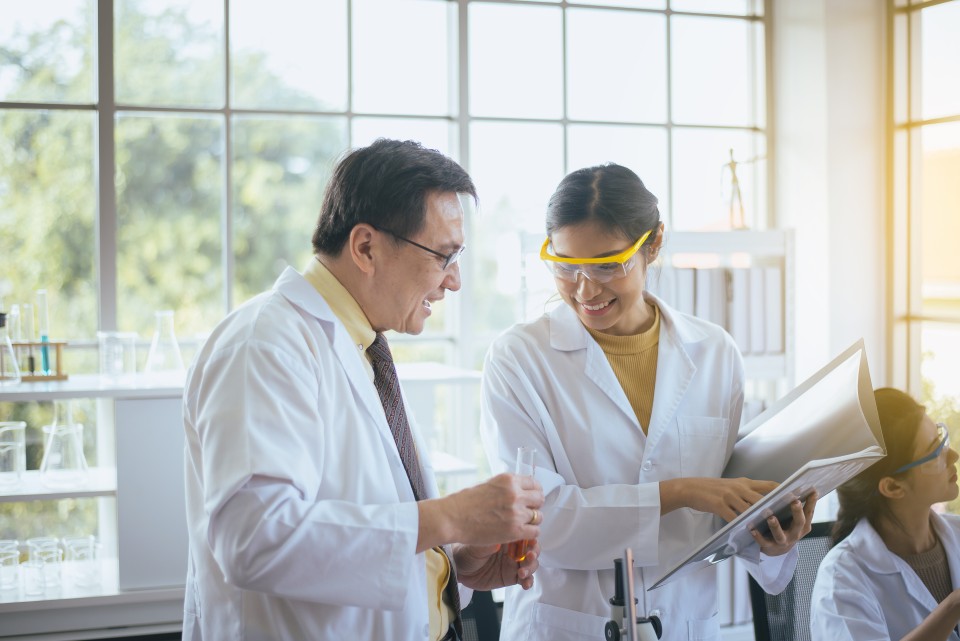 An instructor and student converse in a lab.