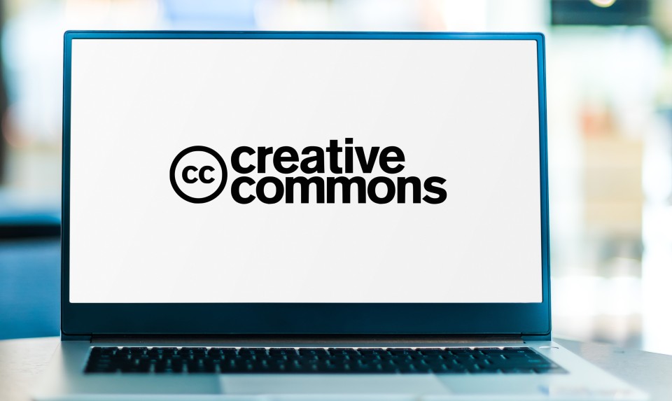 A laptop screen shows the Creative Commons logo.