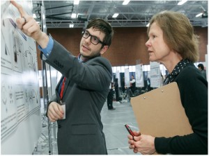 A student and instructor discuss a research poster.